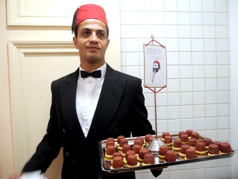 Plateau et serveur. Bouchée rouge inspirée de la forme du chapeau du khédive Ismaïl Pacha.